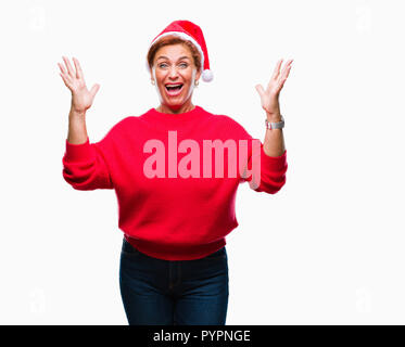 Atrractive redhead caucasian woman wearing christmas hat sur fond isolé et fou fou célèbre pour le succès avec bras levés et de cl Banque D'Images