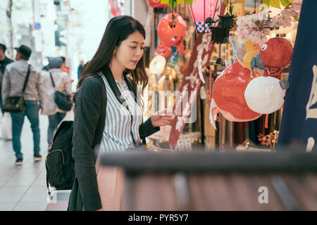 Femme élégante de profiter de la beauté de la lanterne shop. jeune voyageur choisissant en souvenir décoration mignon vendeur dans le marché. girl avoir plaisir à voyager ou Banque D'Images