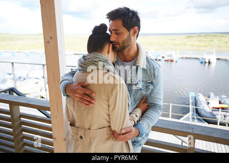 L'amour calme man hugging girlfriend à port maritime Banque D'Images