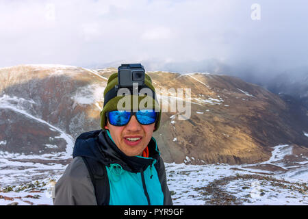 Portrait de l'alpiniste masculins dans les montagnes enneigées, avec un sac à dos Banque D'Images