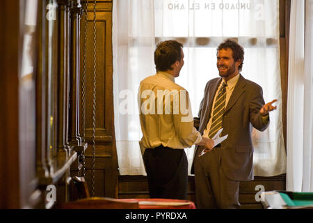 Happy young businessman gesturing tout en parlant à un collègue masculin dans une salle de billard. Banque D'Images