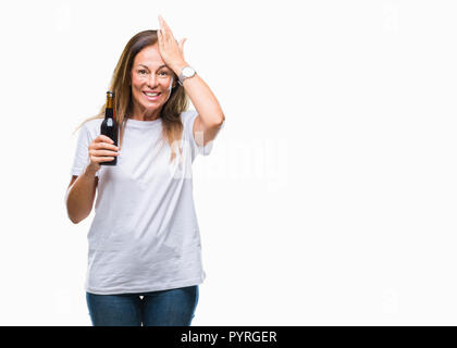 L'âge moyen hispanic woman drinking beer sur fond isolé a souligné avec la main sur la tête, choqué de honte et de surprise, de colère et de frustration face Banque D'Images