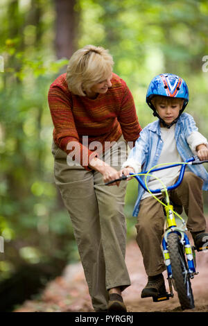 L'enseignement de sa grand-mère son petit-fils à faire du vélo Banque D'Images