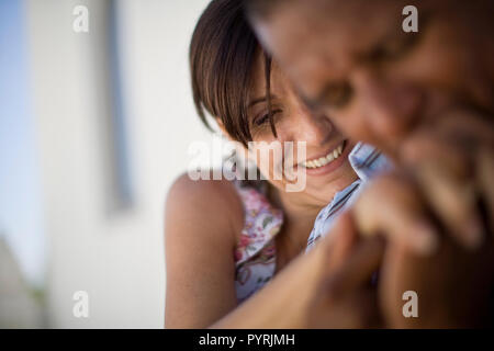 Mid-adult woman d'être embrassé sur la main de son mari. Banque D'Images
