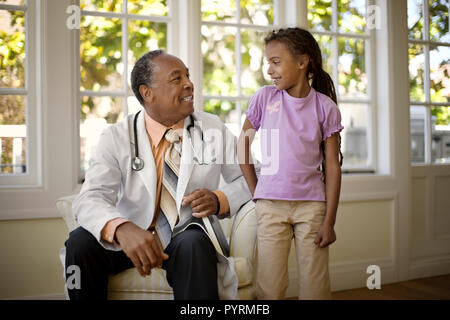 Friendly senior doctor smiling à un jeune patient. Banque D'Images