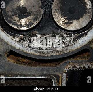 Soupape dans un dépôt sur le couvercle de la boîte de soupapes du moteur. Banque D'Images