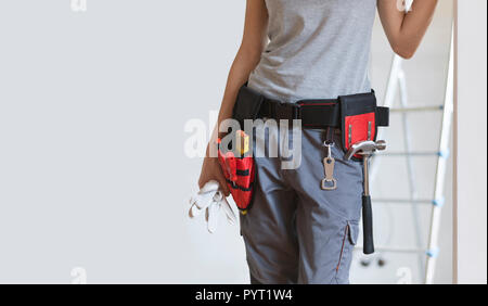 Femme portant une ceinture d'outils et debout, Home makeover et concept de bricolage Banque D'Images