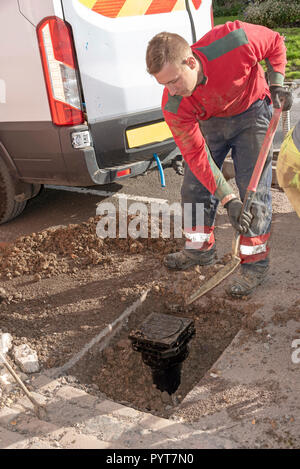 L'installation d'un nouveau compteur d'eau sur la route. UK. Un trou de remplissage de l'homme avec le nouveau compteur ayant été installé Banque D'Images