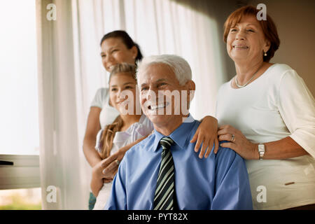 Smiling senior homme et sa famille sourire pour un portrait. Banque D'Images