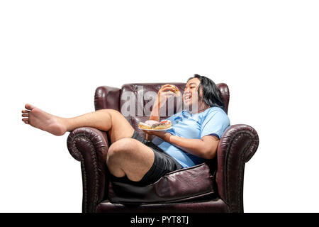 Happy asian fat man snacking donuts sur la plaque dans le canapé isolated over white background. Fat Man concept de régime Banque D'Images