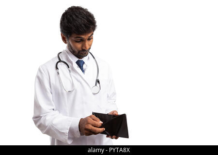 Perplex indian medic l'homme regarde à l'intérieur de porte-monnaie vides comme concept sans numéraire isolé sur fond blanc Banque D'Images