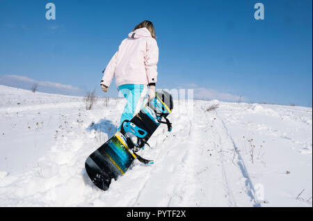 Snowboarder Girl avec un snowboard sur une neige blanche. Banque D'Images