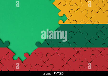 Drapeau de la Lituanie est représenté sur un puzzle avec copie espace vert sur le côté gauche. Banque D'Images