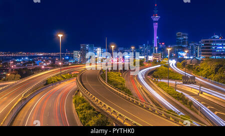 Le trafic de nuit avec centre-ville d'Auckland à l'horizon, Nouvelle-Zélande Banque D'Images