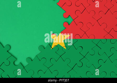 Drapeau du Burkina Faso est représenté sur un puzzle avec copie espace vert sur le côté gauche. Banque D'Images