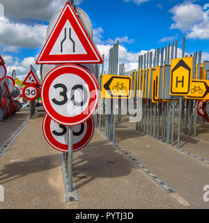 Le rétrécissement de la route d'étranglement signe et vitesse limite signe parmi d'autres lignes de signalisation routière attendent d'être embauchés dans des projets de construction de routes Banque D'Images