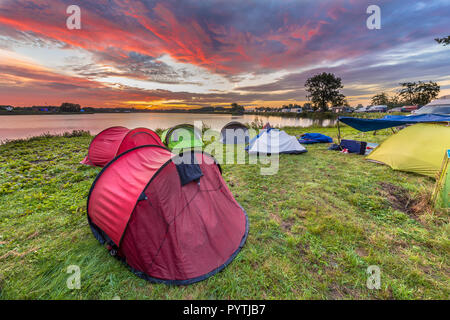 Dome tentes camping près de lac sur un festival de musique camp site sous beau lever Banque D'Images