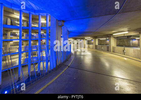 Rampe vide circulaire dans parking souterrain avec éclairage coloré sous un aéroport international Banque D'Images