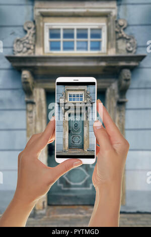 Un touriste prend une photo de l'ancien porte bleue avec de belles colonnes, une visière et une fenêtre. Vieille ville, Riga, Lettonie sur un téléphone mobile Banque D'Images