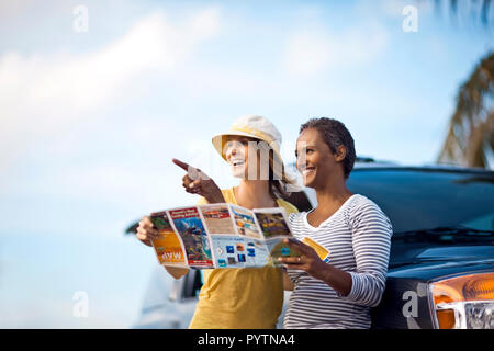Deux amis looking at map, appuyé contre voiture. Banque D'Images