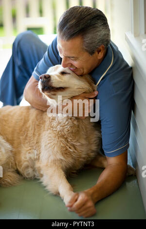 Homme assis avec son chien sur la véranda. Banque D'Images