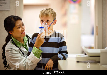 Médecin met un masque à oxygène sur le jeune garçon. Banque D'Images