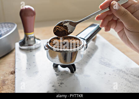 Place de femme de la terre fraîche café dans portafilter de barista. Concept de routine du matin Banque D'Images