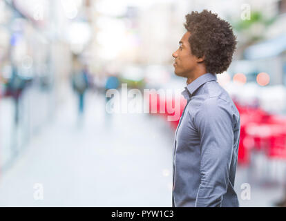 Au cours de l'homme afro-américain à la recherche de fond isolé à l'autre, posent avec profil relax visage naturel avec sourire confiant. Banque D'Images