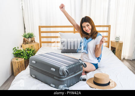 Beaux Jeunes professionnels jolie fille asiatique'valise bagages sur lit dans la chambre, prêt à aller à l'étranger vol en solo. Voyageur en Asie, le tourisme asiatique Banque D'Images