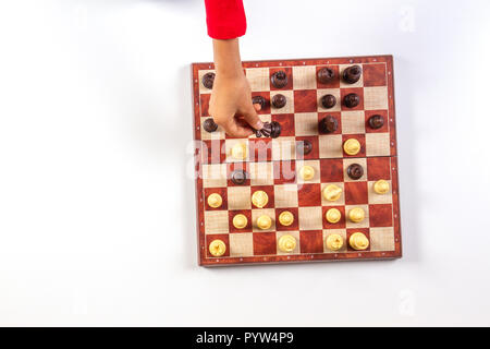 Kid mains sur un échiquier jouant aux échecs. Vue d'en haut Banque D'Images