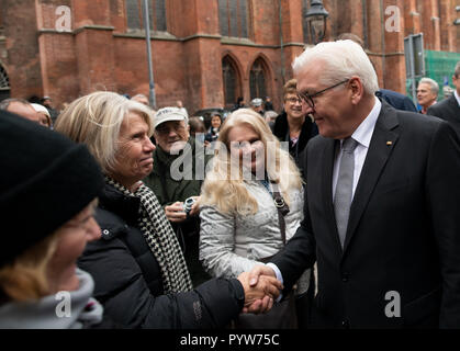 Lübeck, Allemagne. 30 octobre 2018, le Schleswig-Holstein, Lübeck : Président fédéral Frank-Walter Steinmeier se félicite de touristes étrangers au début de sa visite à la Marienkirche de Lübeck. En début de soirée, Steinmeier donnera cette année, Willy Brandt discours à la Musik- und Kongresshalle. Chaque année, la maison Willy Brandt, en coopération avec la ville hanséatique de Lübeck, invite une personnalité pour analyser l'héritage de Willy Brandt en appuyant sur les problèmes politiques et sociaux de notre temps. Photo : Rainer Jensen/dpa dpa : Crédit photo alliance/Alamy Live News Banque D'Images