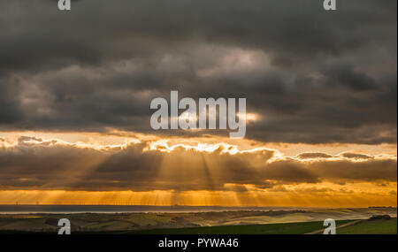 Firle, Lewes, East Sussex, Royaume-Uni. 30 octobre 2018..vue de Firle Beacon dans les South Downs regardant sur Seaford & Rampion parc éolien offshore alors que le soleil se brise à travers la couverture nuageuse peu avant le coucher du soleil. Beaucoup plus froid maintenant avec une brise raide du nord-est.. Banque D'Images