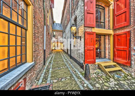 Ruelle historique avec fenêtres et écoutilles rouge dans la ville de Groningen aux Pays-Bas Banque D'Images