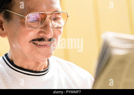 Senior man reading newspaper Banque D'Images