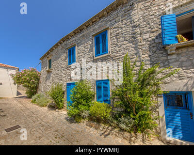 Complexe d'appartements traditionnels croates avec fenêtres peintes en bleu clair dans la ville d'Osor sur l'île de Cres, Istrie, Croatie, Europe Banque D'Images