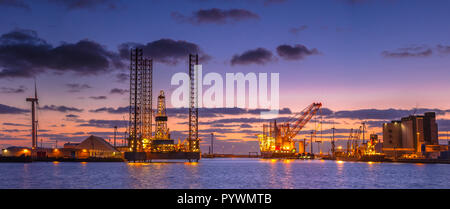 Panorama des plates-formes pétrolières en construction dans un port sous beau coucher du soleil Banque D'Images