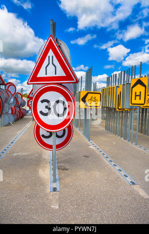 Le rétrécissement de la route d'étranglement signe et vitesse limite signe parmi d'autres lignes de signalisation routière attendent d'être embauchés dans des projets de construction de routes Banque D'Images