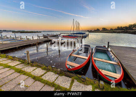 Scène paysage ultra grand angle de la location des barques dans une marina au lever du soleil sur un lac dans les Pays-Bas Banque D'Images