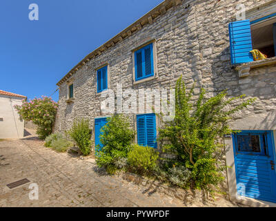 Complexe d'appartements traditionnels croates avec fenêtres peintes en bleu clair dans la ville d'Osor sur l'île de Cres, Istrie, Croatie, Europe Banque D'Images