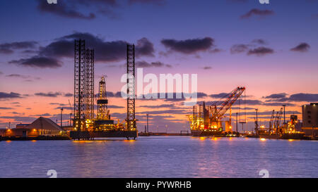 Les plates-formes pétrolières en construction dans un port sous beau coucher du soleil Banque D'Images