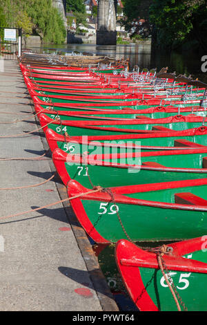 Peint en vert et rouge les barques alignées à côté de la rivière Nidd dans Knaresborough, Yorkshire du Nord attendent les visiteurs à les sortir sur la rivière Banque D'Images