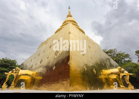 Stupa pyramide avec des statues d'éléphants d'or sous un ciel dramatique au temple Wat Phra Singh, Chiang Mai, Thaïlande Banque D'Images