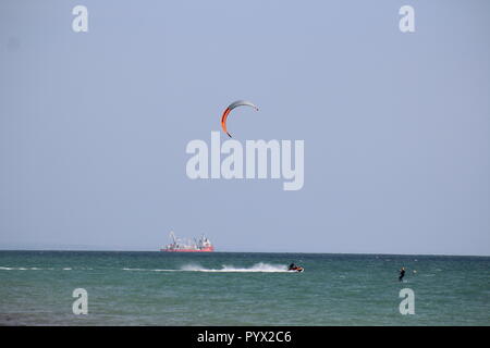 Ski nautique par un surfeur vent avec un bateau de fret dans la distance dans la manche Banque D'Images