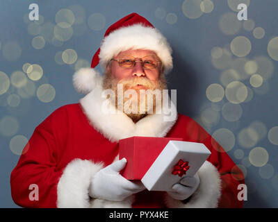 Santa Claus holding ouvert boîte-cadeau Banque D'Images