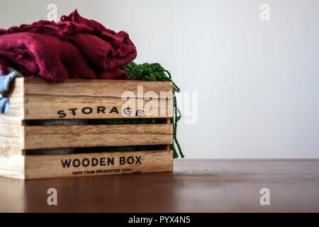 Donation box avec des vêtements sur table en bois Banque D'Images