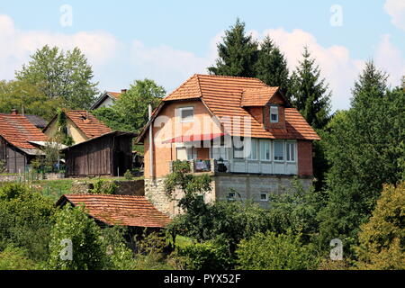 Brique rouge inachevé suburban family house situé sur le dessus de la petite colline à côté du jardin en bois cabane entourée d'autres maisons plus anciennes Banque D'Images