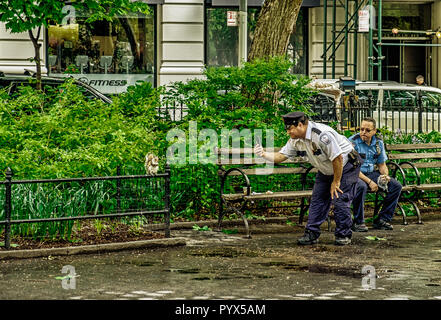 New York City, USA, mai 2018, un policier sur sa pause de prendre une photo d'un écureuil dans le Madison Square Park Banque D'Images