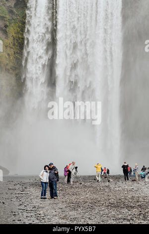 Les touristes visitant la célèbre cascade de Skogafoss dans le sud de l'Islande. Banque D'Images