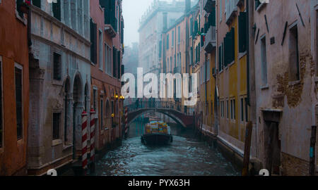 Seul bateau croisière sur un canal à Venise Italie, hiver Matin brumeux Banque D'Images