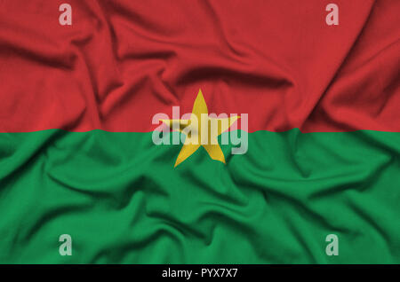Drapeau du Burkina Faso est représenté sur un tissu de sport avec de nombreux plis. L'équipe Sport forme banner Banque D'Images